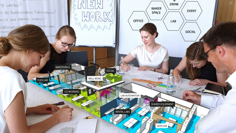 People working at a table with a 3D model