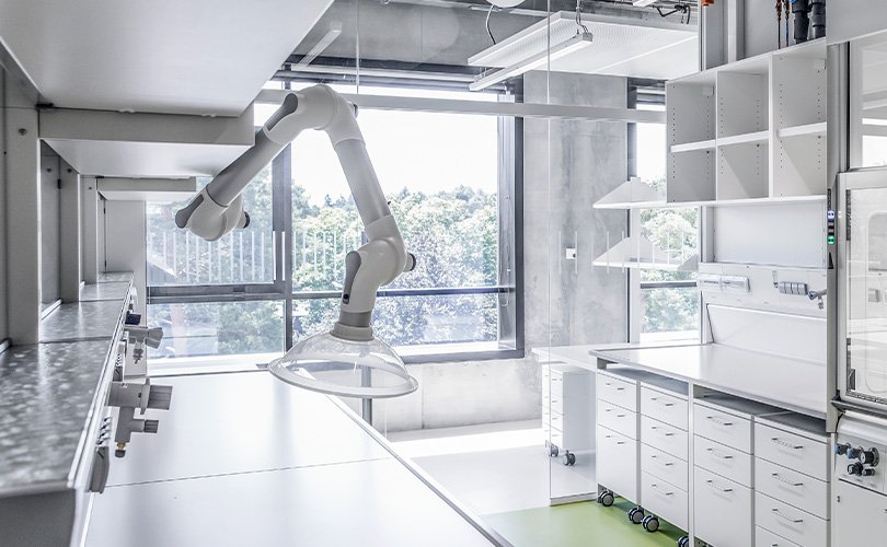 Modern laboratory workspace with articulated extraction arm mounted above a workbench