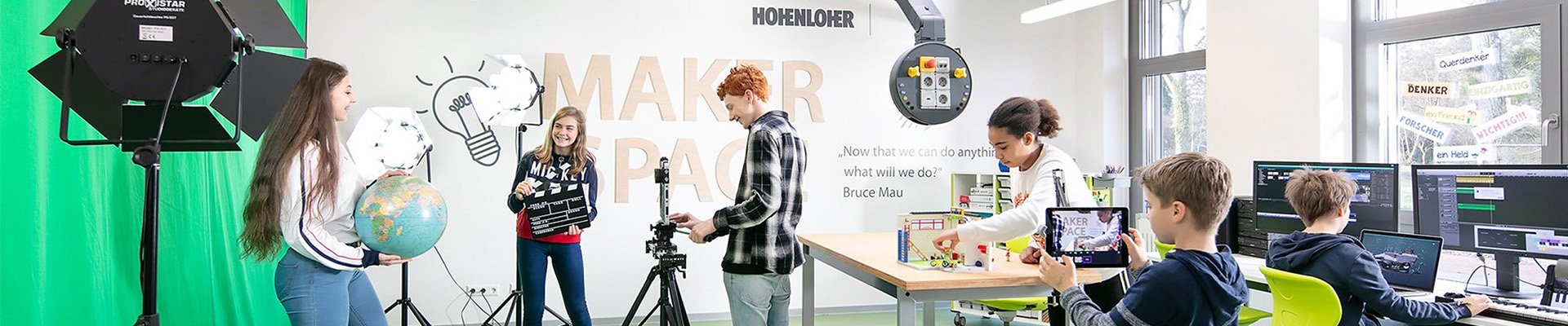 Students working creatively in a modern makerspace with green screen and media setup