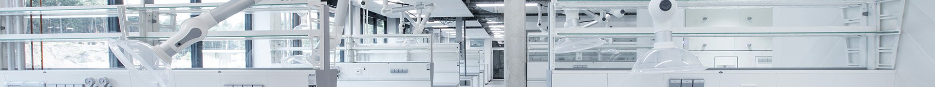 Several local extraction arms mounted on ceiling system in a laboratory