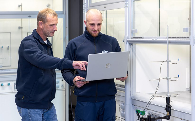 Two technicians reviewing data on a laptop in laboratory