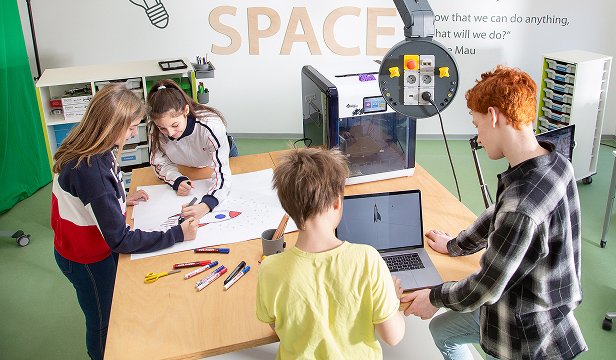 Students engaging in hands-on experiments at a modular makerspace table