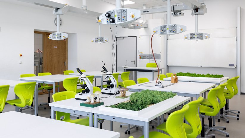 Laboratory with green chairs, microscopes, and plants