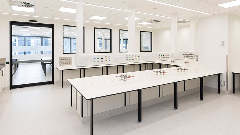 Minimal laboratory at CSL Melbourne with white benches and daylight.